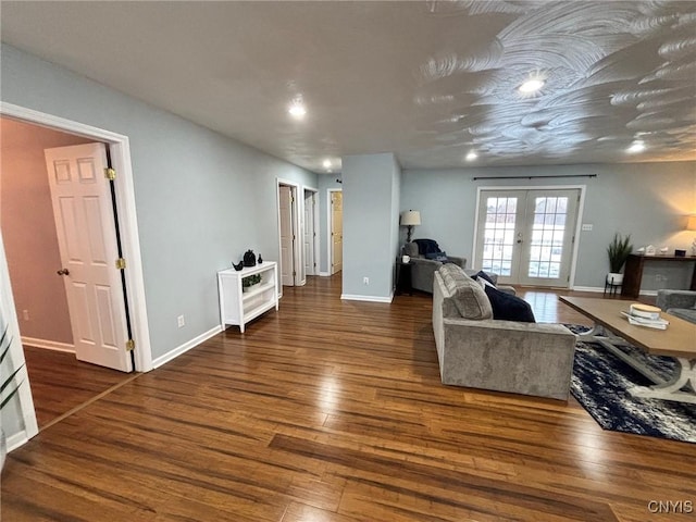 living area featuring baseboards, wood finished floors, and french doors