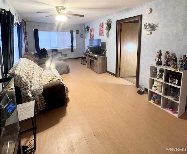 living area with ceiling fan and wood finished floors