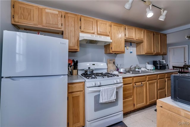 kitchen featuring white appliances, under cabinet range hood, light countertops, and a sink