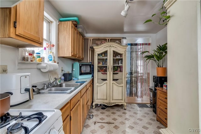 kitchen featuring light floors, light countertops, a sink, white range with gas cooktop, and track lighting