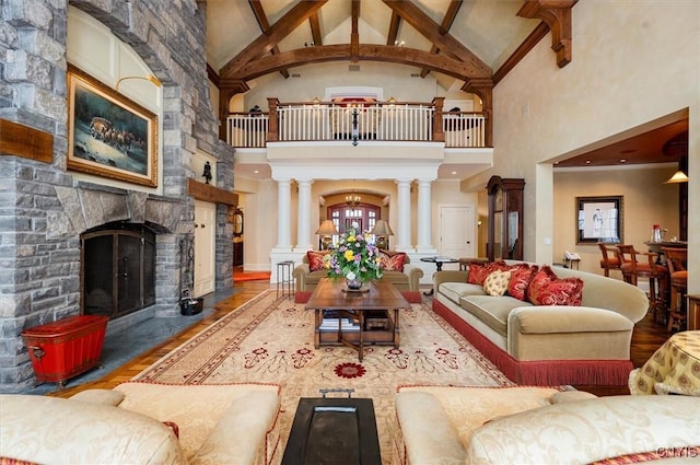 3789 State Route 12, Kirkland, NY 13323 - living area with a fireplace, wood finished floors, high vaulted ceiling, beamed ceiling, and ornate columns