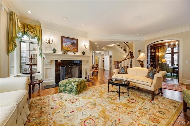 3789 State Route 12, Kirkland, NY 13323 - living area featuring arched walkways, stairs, ornamental molding, wood finished floors, and a premium fireplace