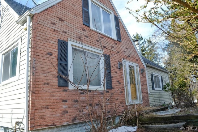 view of side of home with brick siding and crawl space