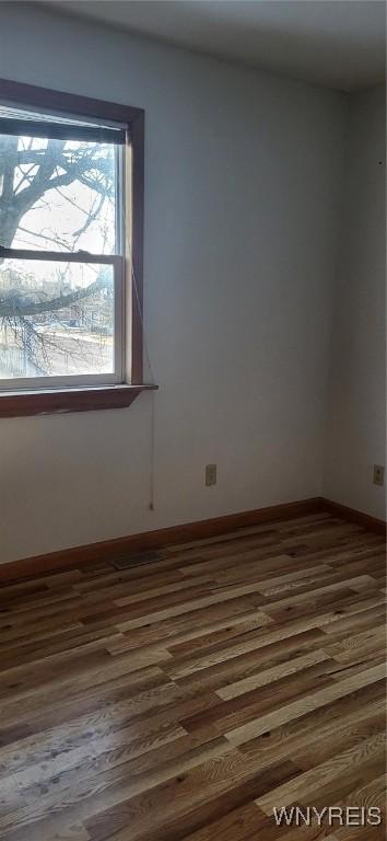 empty room featuring dark wood-style flooring and baseboards