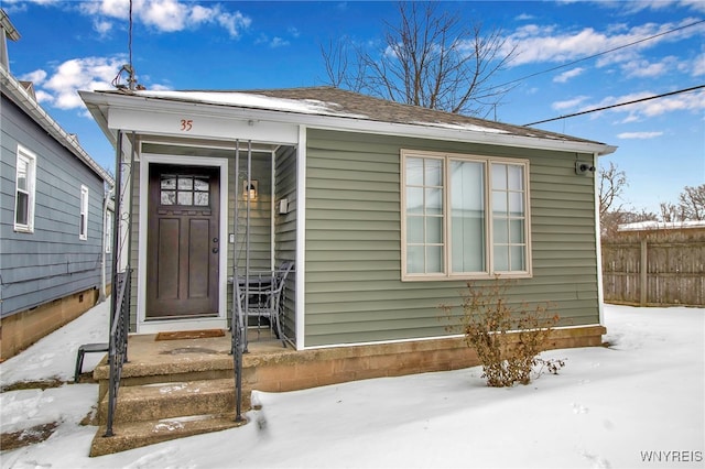 snow covered property entrance featuring fence