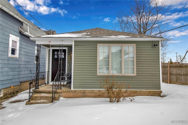 snow covered property entrance with fence