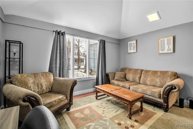 living area with lofted ceiling, light wood-style flooring, and baseboards