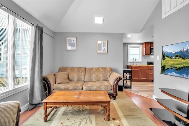 living area featuring vaulted ceiling and light wood-type flooring