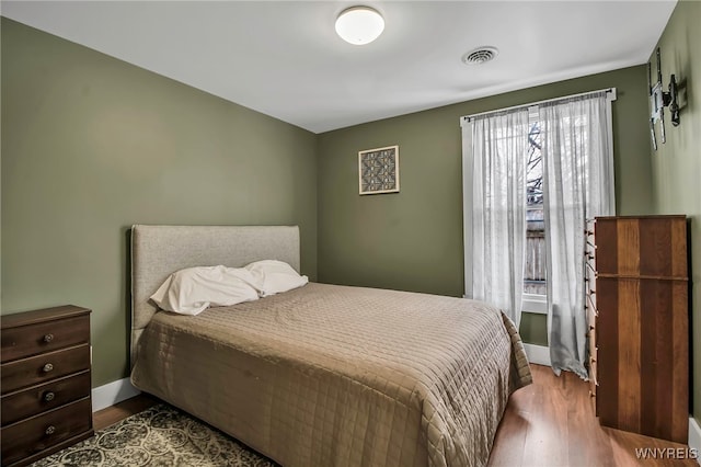 bedroom featuring dark wood-type flooring, visible vents, and baseboards