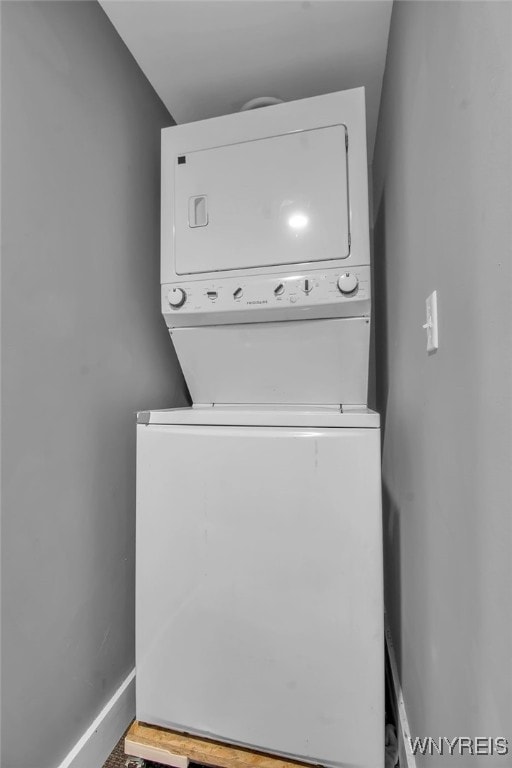 laundry room featuring stacked washer / dryer, laundry area, and baseboards