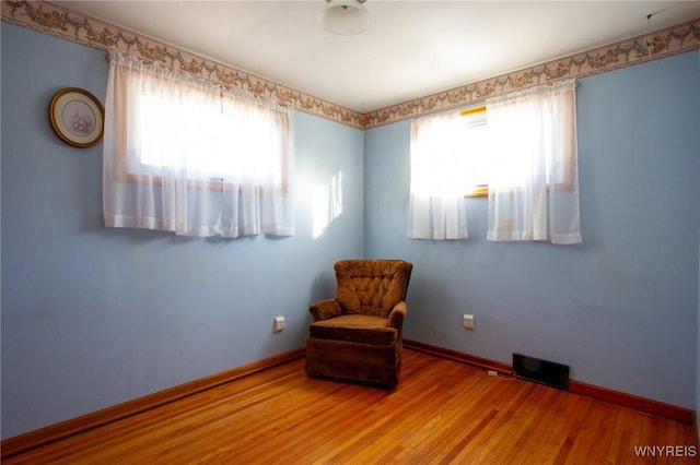 unfurnished room featuring a wealth of natural light, baseboards, and wood finished floors