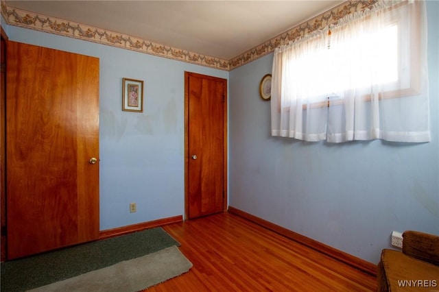 interior space featuring wood finished floors and baseboards