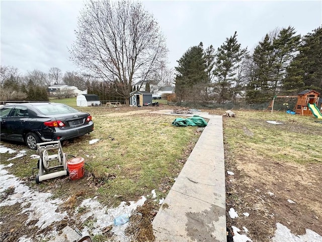 view of yard featuring an outbuilding, a shed, and a playground