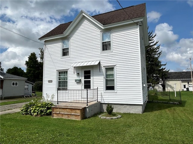 view of front of home with a front lawn and a shingled roof