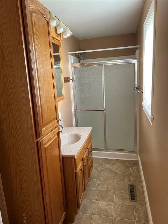 full bathroom featuring visible vents, a shower stall, vanity, baseboards, and tile patterned floors