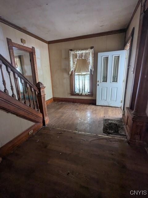 entrance foyer featuring stairs, crown molding, baseboards, and wood finished floors