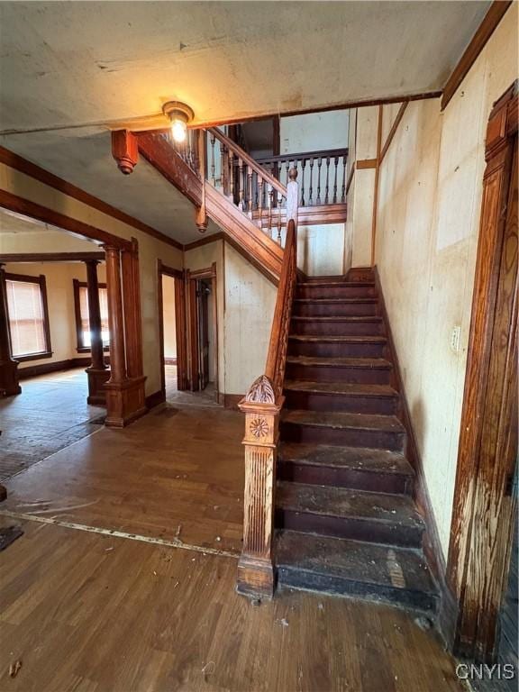 stairs featuring ornamental molding and wood-type flooring