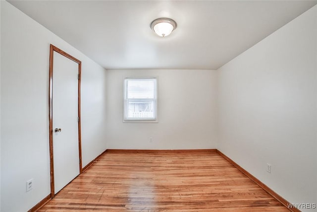 unfurnished room with light wood finished floors and baseboards