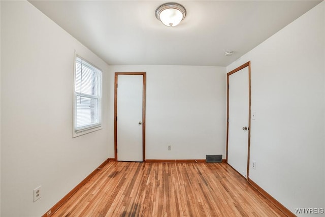 unfurnished bedroom featuring light wood-style flooring, visible vents, and baseboards