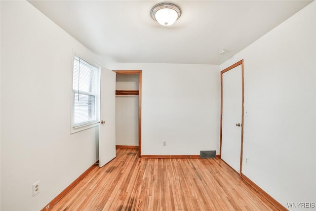 unfurnished bedroom with light wood finished floors, a closet, visible vents, and baseboards