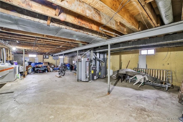 basement with heating unit, water heater, and washing machine and clothes dryer