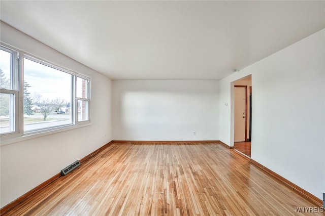 spare room with light wood-type flooring, baseboards, and visible vents