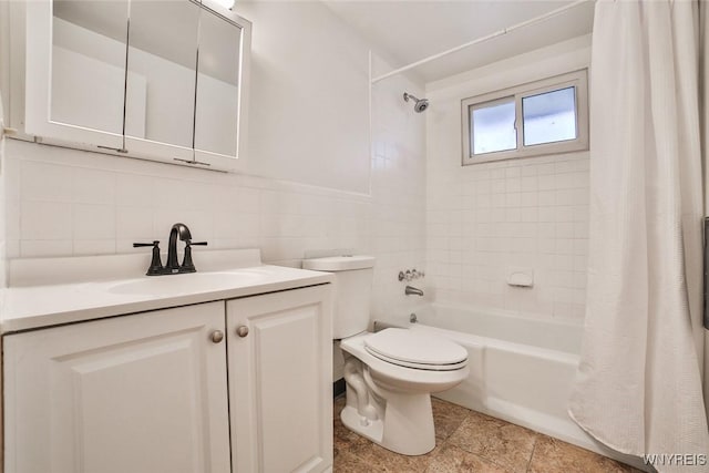 bathroom with vanity, shower / bath combo with shower curtain, toilet, and tile walls