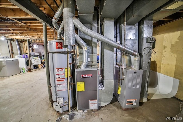 utilities featuring heating unit, water heater, and washing machine and clothes dryer