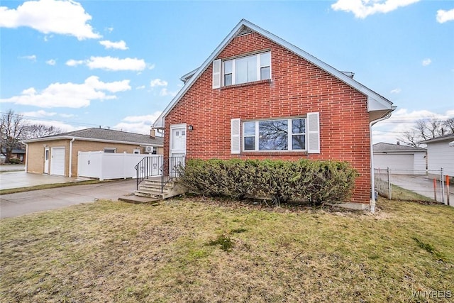 view of front of home featuring a garage, a front lawn, fence, and brick siding