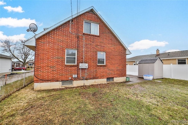 view of property exterior with brick siding, a yard, a storage unit, a fenced backyard, and an outdoor structure