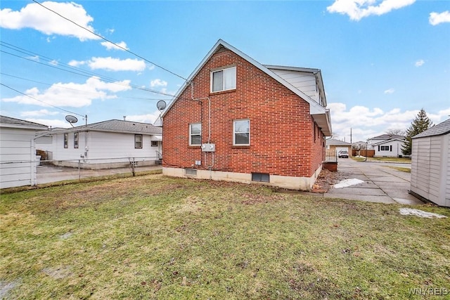 back of property featuring brick siding, a lawn, and fence