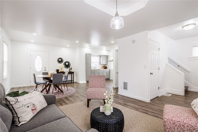 living area featuring baseboards, visible vents, wood finished floors, stairs, and recessed lighting