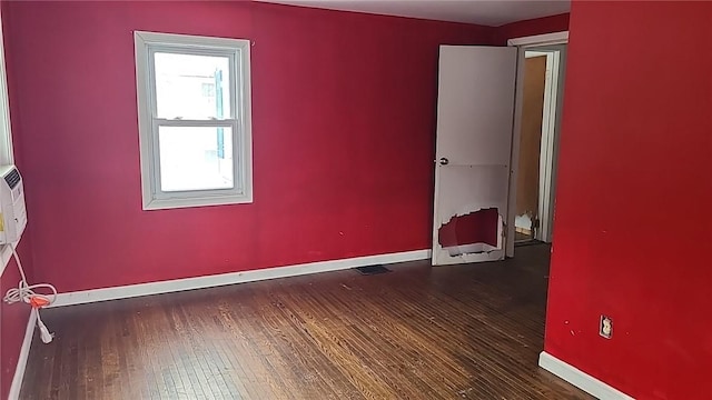 unfurnished room with baseboards and wood finished floors