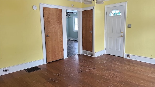 entrance foyer featuring a baseboard radiator, visible vents, baseboards, and wood finished floors