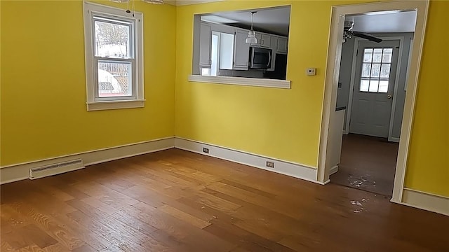 spare room with dark wood-style floors, baseboards, visible vents, and a ceiling fan