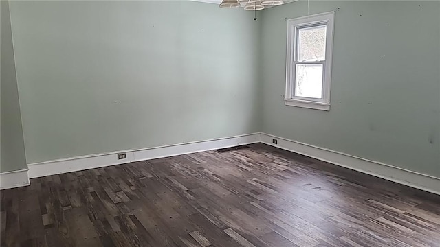 unfurnished room featuring dark wood-style flooring, visible vents, and baseboards