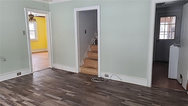 unfurnished room featuring stairs, baseboards, and wood finished floors