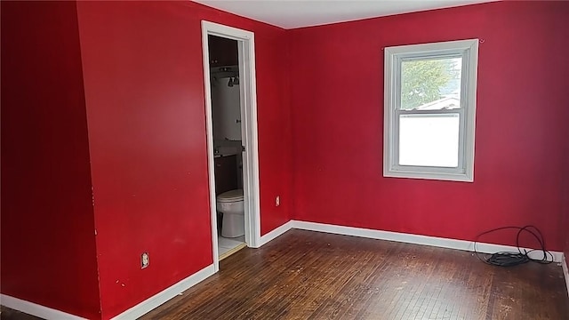 empty room featuring hardwood / wood-style flooring and baseboards