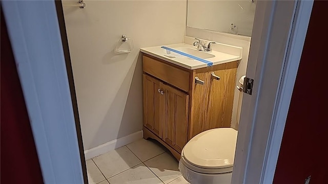 half bath featuring tile patterned flooring, toilet, vanity, and baseboards