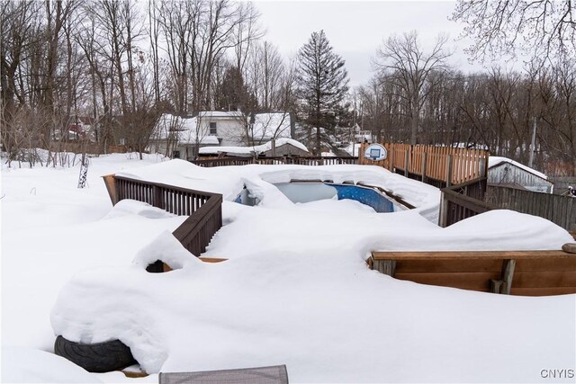 yard covered in snow with fence and a deck