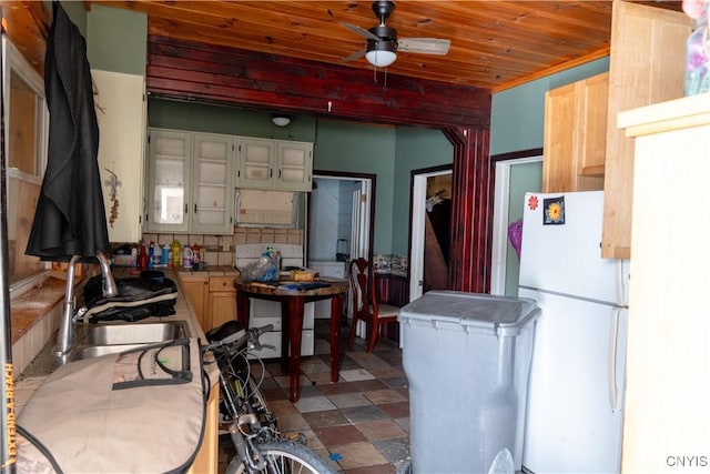 kitchen featuring wooden ceiling, range with electric cooktop, a sink, backsplash, and freestanding refrigerator