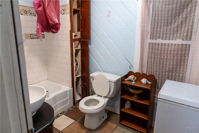 full bath with toilet, a tub, wooden walls, and a shower