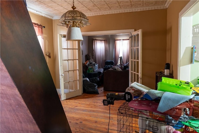 interior space with hardwood / wood-style flooring, an ornate ceiling, ornamental molding, and french doors