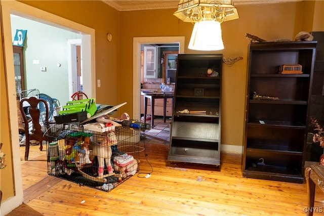 interior space with crown molding, a chandelier, and wood finished floors