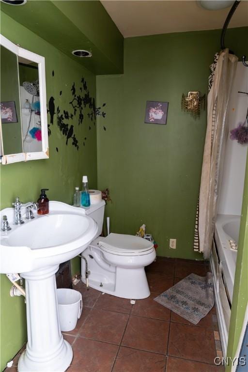 full bathroom with shower / bath combination with curtain, tile patterned flooring, and toilet