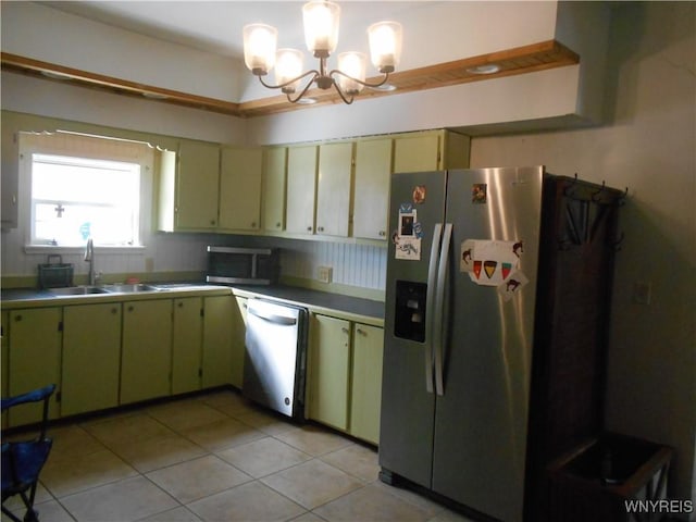 kitchen with light tile patterned floors, a chandelier, cream cabinets, a sink, and appliances with stainless steel finishes