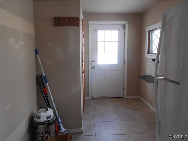 entryway with light tile patterned floors and baseboards