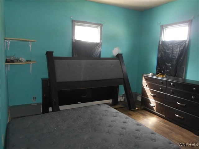 bedroom with multiple windows and wood finished floors