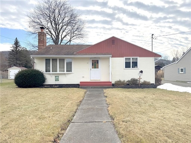 bungalow-style home featuring a front yard, roof with shingles, and a chimney