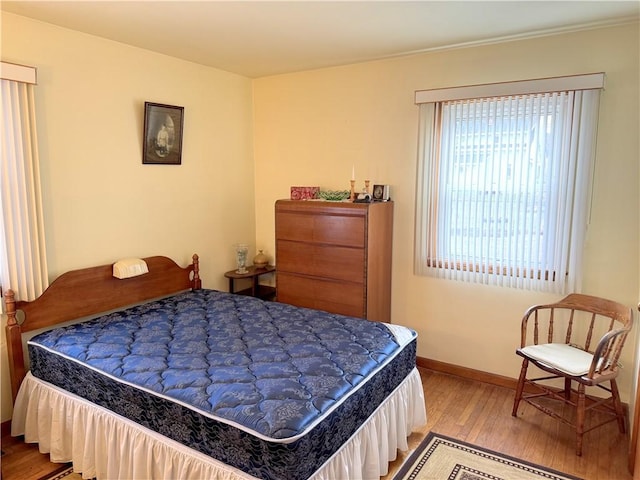 bedroom with baseboards and wood finished floors